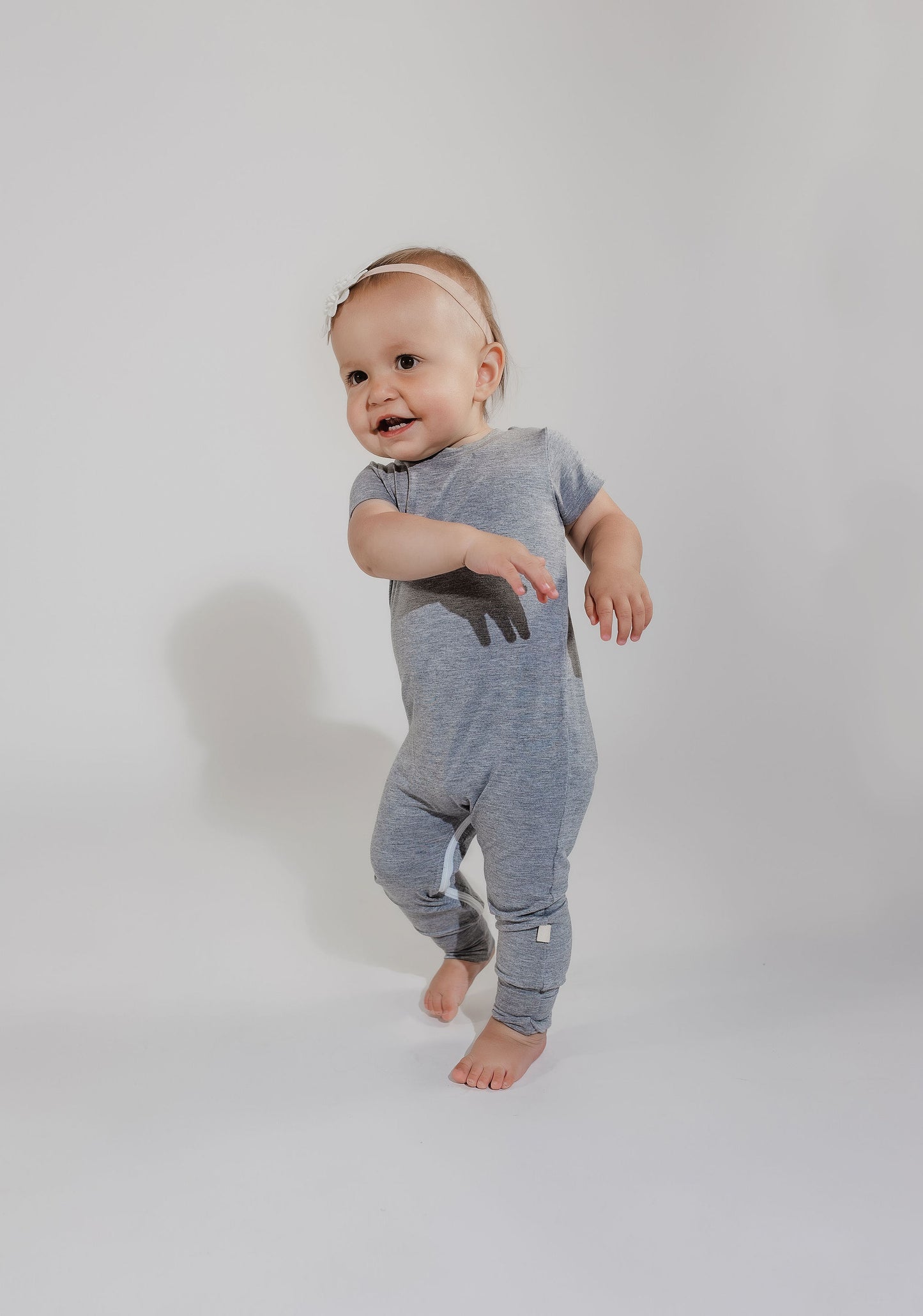 Little girl walking around wearing a grey Bamboo Lyocell Zipease Romper