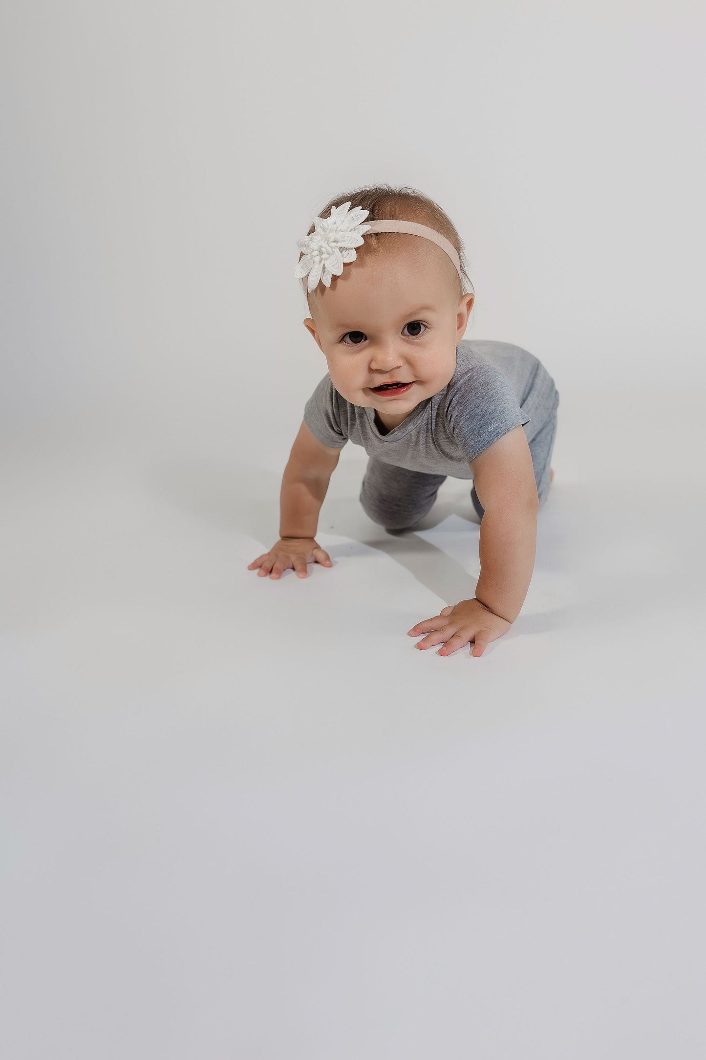 Little girl crawling toward the camera wearing a grey Bamboo Lyocell Zipease Romper
