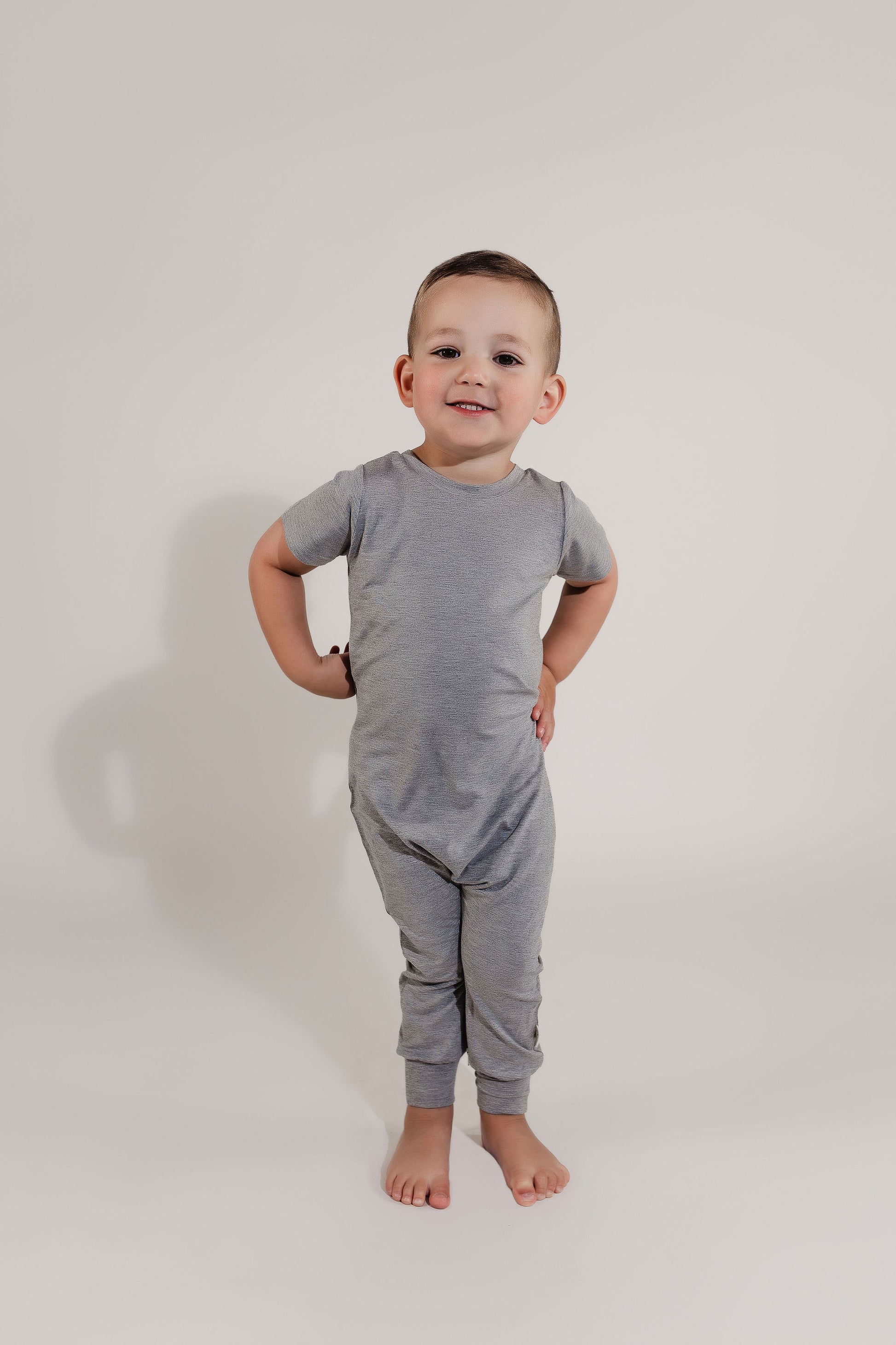 Little boy posing wearing a grey Bamboo Lyocell Zipease Romper
