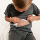 Child wearing a medical device on their abdomen against a white background wearing a Bamboo Lyocell Zipease Romper teal blue green gastrostomy tube gtube g-tube 