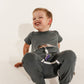 Child wearing a gray outfit with a visible medical device on a white background wearing a Bamboo Lyocell Zipease Romper gtube g-tube gastrostomy tube